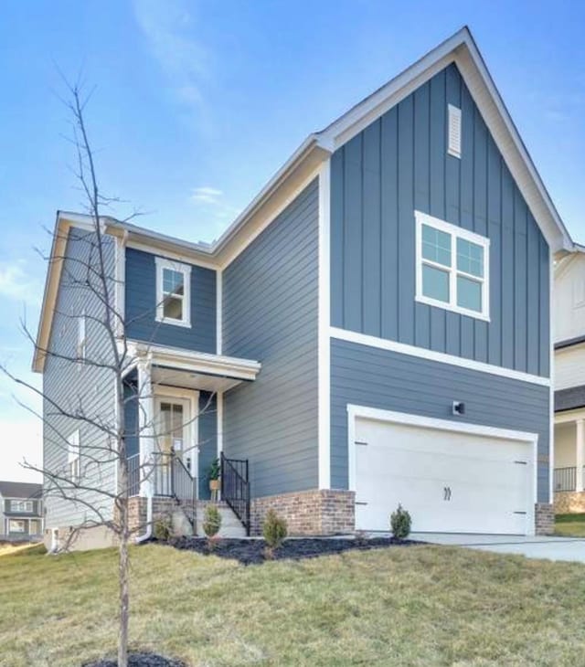 view of front of house with a garage, brick siding, board and batten siding, and a front lawn