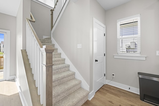 stairs featuring wood finished floors and baseboards