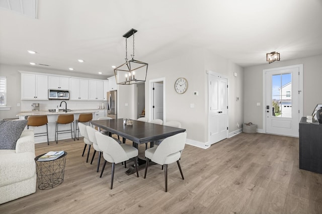 dining space featuring a chandelier, recessed lighting, light wood-style flooring, and baseboards