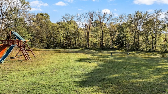 view of yard with a playground and a view of trees