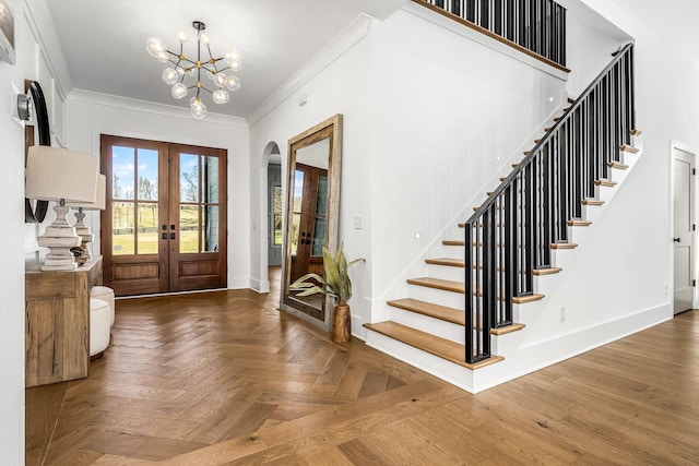 entryway featuring crown molding, baseboards, stairway, french doors, and arched walkways