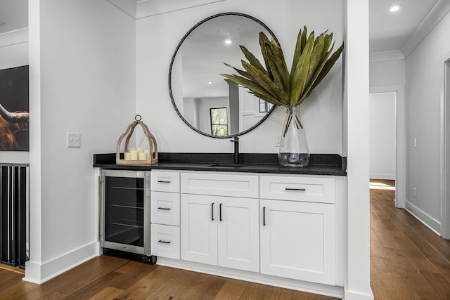 bathroom featuring baseboards, wine cooler, recessed lighting, wood finished floors, and vanity