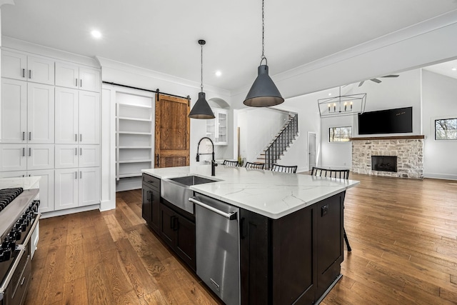 kitchen with a sink, dishwasher, dark wood finished floors, and white cabinetry