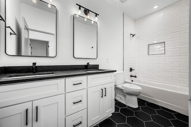 full bath featuring tile patterned flooring, double vanity, toilet, and a sink