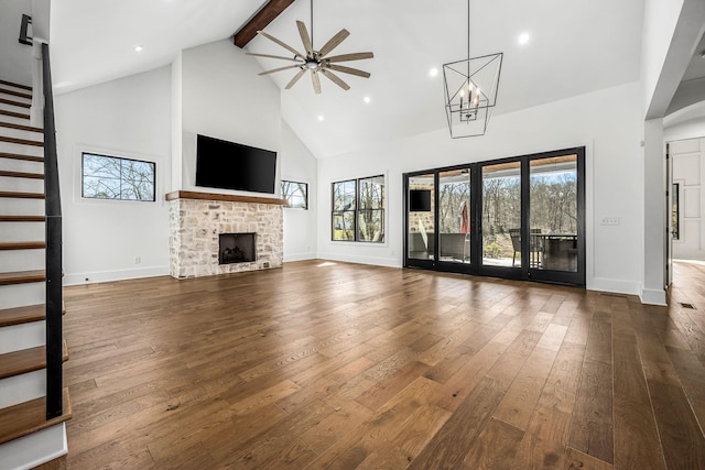 unfurnished living room with beamed ceiling, dark wood-type flooring, high vaulted ceiling, baseboards, and stairs