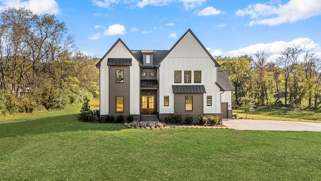 modern farmhouse featuring a standing seam roof, a front lawn, concrete driveway, board and batten siding, and metal roof