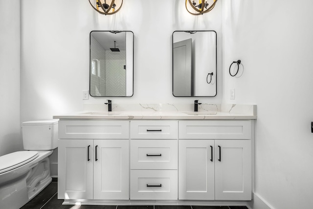 full bath with double vanity, toilet, baseboards, and a sink