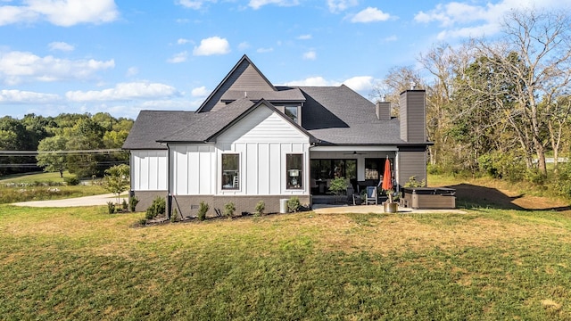 rear view of property with board and batten siding, a shingled roof, a lawn, a chimney, and a patio