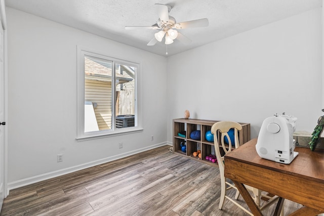 office space with a ceiling fan, wood finished floors, baseboards, and a textured ceiling