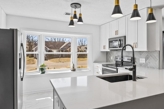 kitchen featuring plenty of natural light, marble finish floor, and appliances with stainless steel finishes