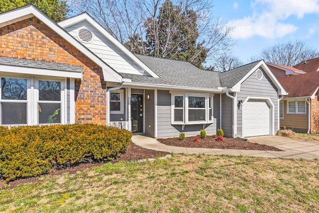 ranch-style house featuring an attached garage, concrete driveway, a front lawn, and a shingled roof