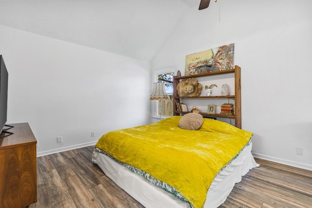 bedroom with baseboards, lofted ceiling, wood finished floors, and a ceiling fan