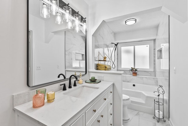 bathroom featuring marble finish floor, toilet, vanity, and a garden tub