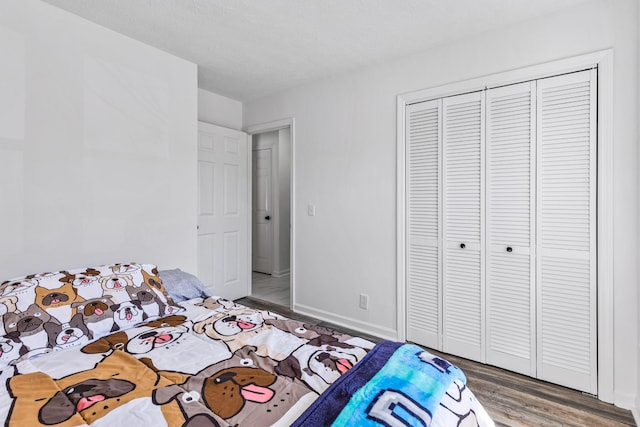 unfurnished bedroom featuring a closet, baseboards, and wood finished floors