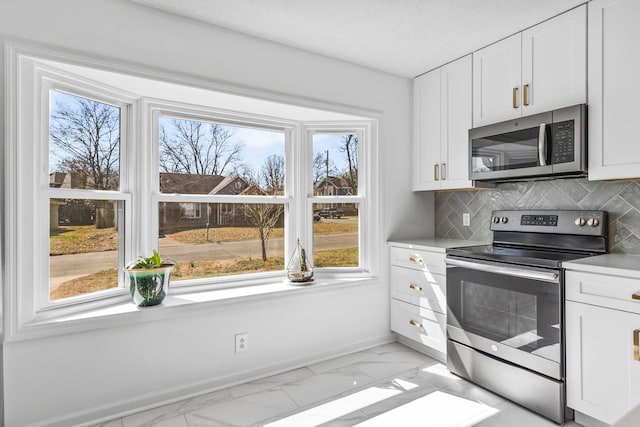 kitchen with stainless steel appliances, marble finish floor, decorative backsplash, and white cabinetry