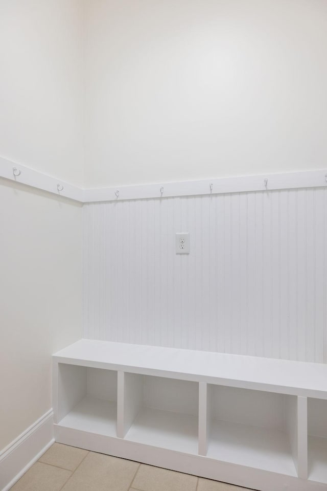 mudroom with wainscoting and tile patterned flooring