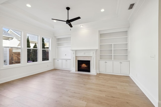 unfurnished living room with crown molding, baseboards, a fireplace with flush hearth, light wood-type flooring, and a ceiling fan