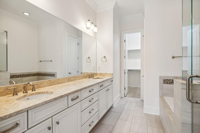 bathroom featuring double vanity, ornamental molding, tiled bath, and a sink