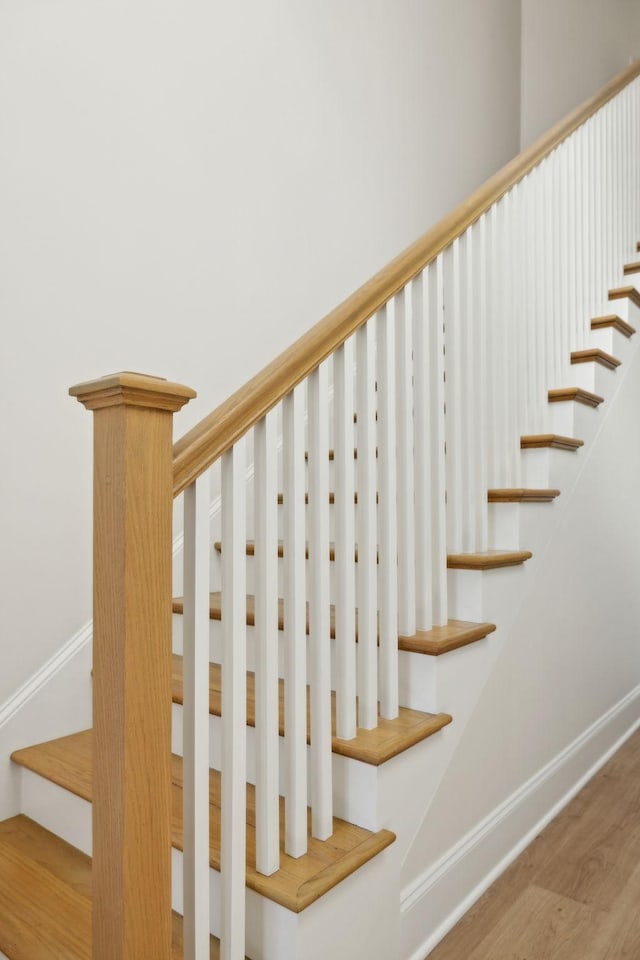 stairs with wood finished floors and baseboards