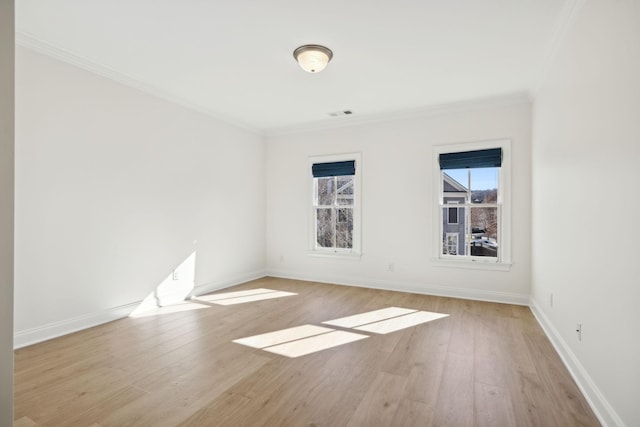 empty room featuring light wood-style floors, a healthy amount of sunlight, and crown molding