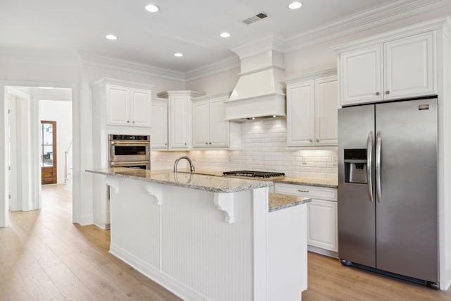 kitchen featuring visible vents, light wood-type flooring, custom range hood, stainless steel appliances, and white cabinetry