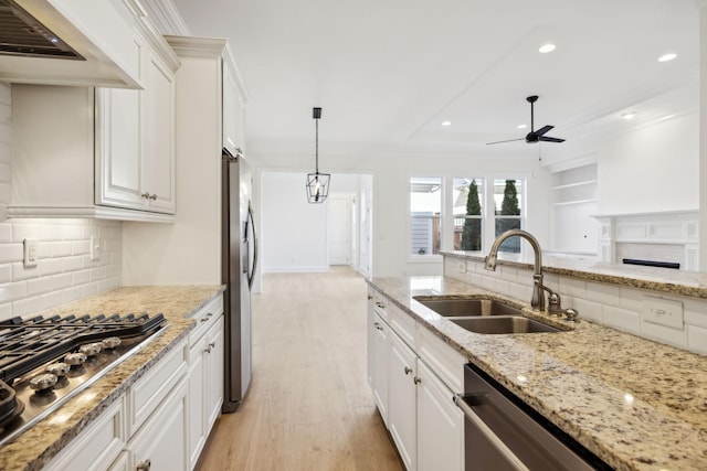 kitchen with ceiling fan, stainless steel appliances, white cabinetry, and a sink