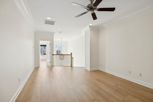 spare room with visible vents, crown molding, baseboards, ceiling fan, and light wood-style flooring