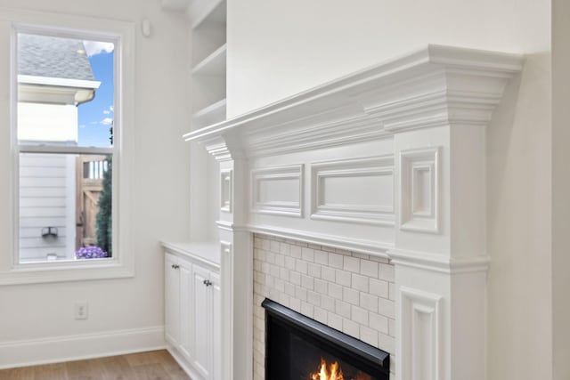 details with a fireplace, baseboards, and wood finished floors