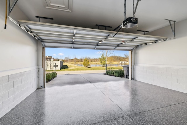 garage featuring a garage door opener and concrete block wall