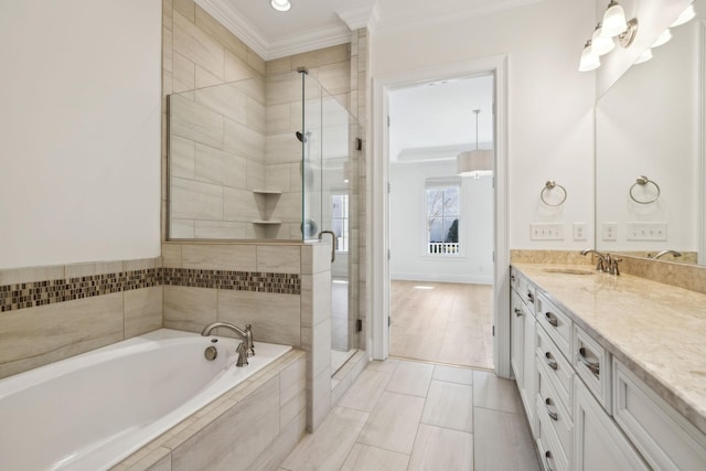 full bathroom with a garden tub, vanity, a shower stall, and crown molding