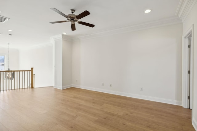 empty room with visible vents, ornamental molding, light wood-style floors, baseboards, and ceiling fan