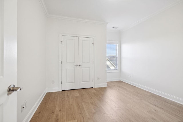 unfurnished bedroom with visible vents, baseboards, light wood-style flooring, and crown molding