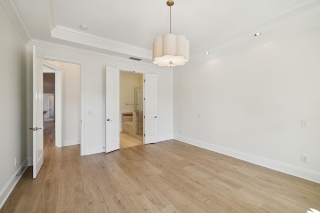 unfurnished bedroom with a raised ceiling, light wood-style flooring, baseboards, and ornamental molding