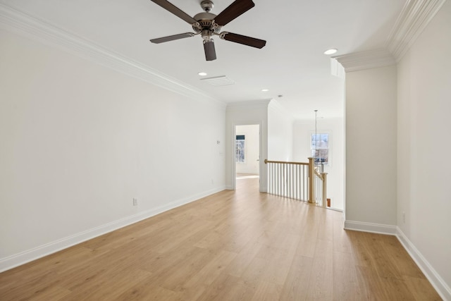 spare room featuring ceiling fan, light wood-type flooring, baseboards, and ornamental molding