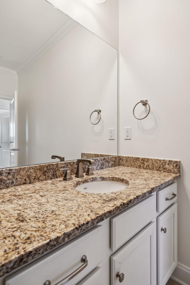 bathroom featuring vanity, baseboards, and ornamental molding