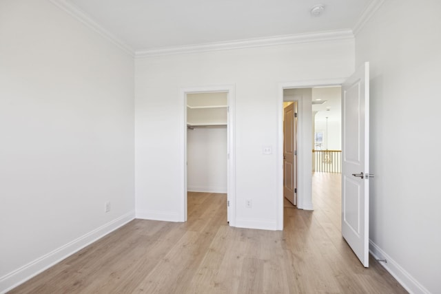 unfurnished bedroom with light wood-type flooring, baseboards, and crown molding