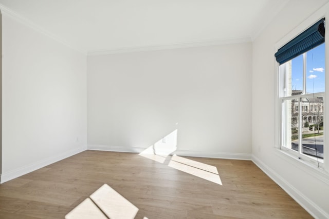 unfurnished room featuring a healthy amount of sunlight, wood finished floors, and crown molding