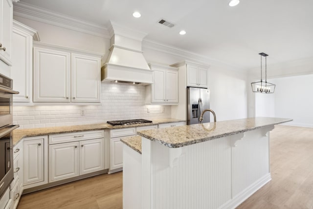 kitchen featuring visible vents, custom exhaust hood, appliances with stainless steel finishes, crown molding, and light wood-type flooring