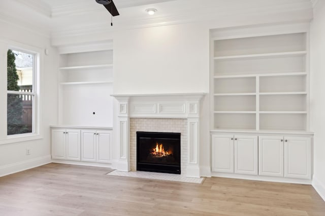 unfurnished living room with a fireplace with flush hearth, light wood-type flooring, ceiling fan, and ornamental molding