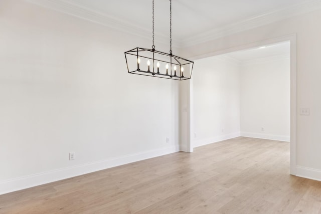 unfurnished dining area featuring baseboards, a notable chandelier, light wood-style flooring, and crown molding