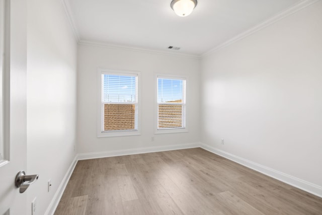 unfurnished room with visible vents, light wood-style flooring, baseboards, and ornamental molding