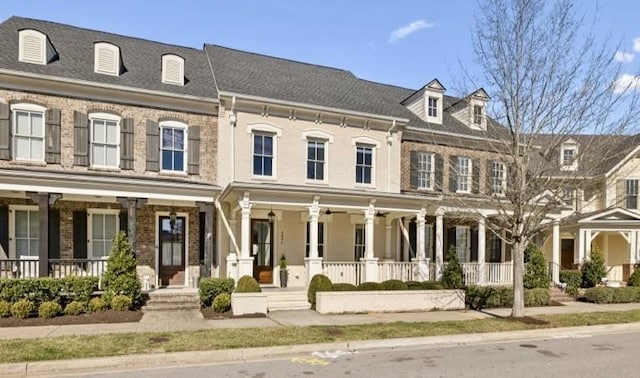 view of property featuring brick siding and a porch