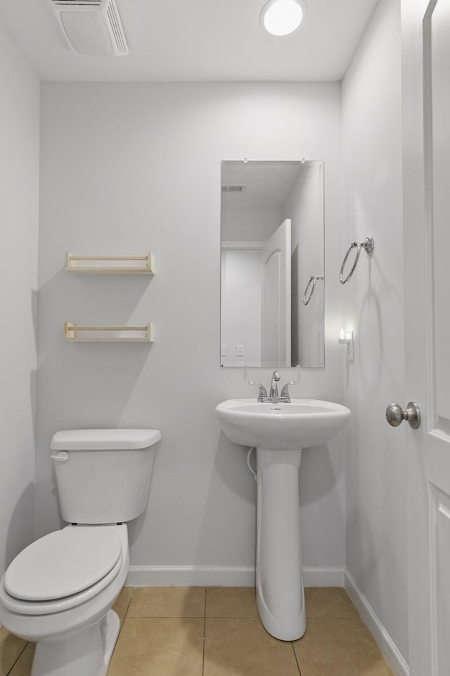 bathroom with tile patterned flooring, toilet, visible vents, and baseboards