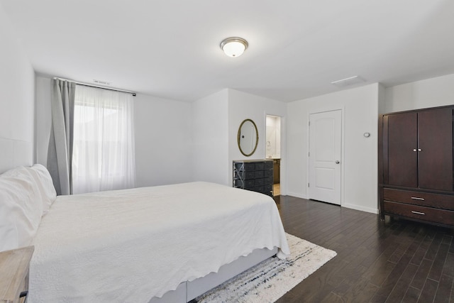 bedroom featuring connected bathroom, baseboards, and dark wood-style floors