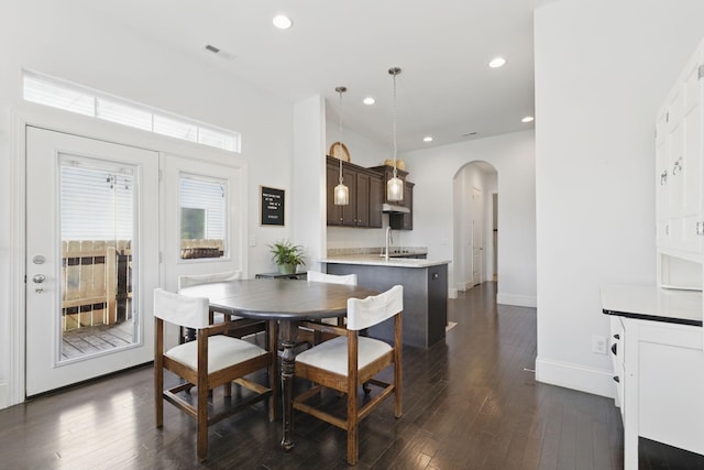 dining room featuring visible vents, recessed lighting, arched walkways, and dark wood-style flooring