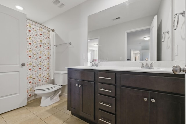 bathroom with visible vents, toilet, a sink, tile patterned flooring, and double vanity