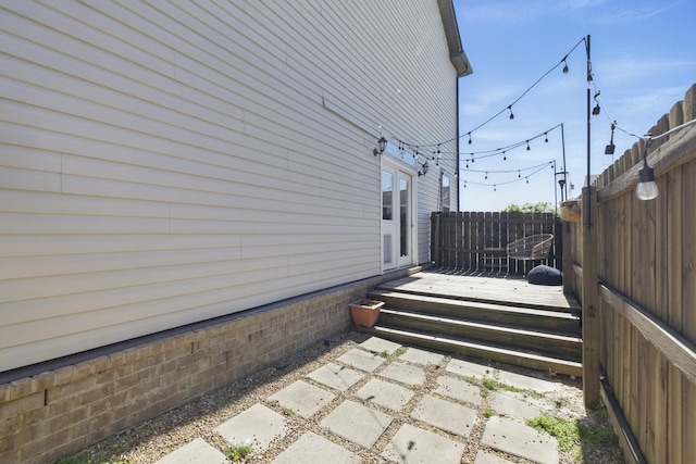 exterior space featuring a patio area, a wooden deck, and fence