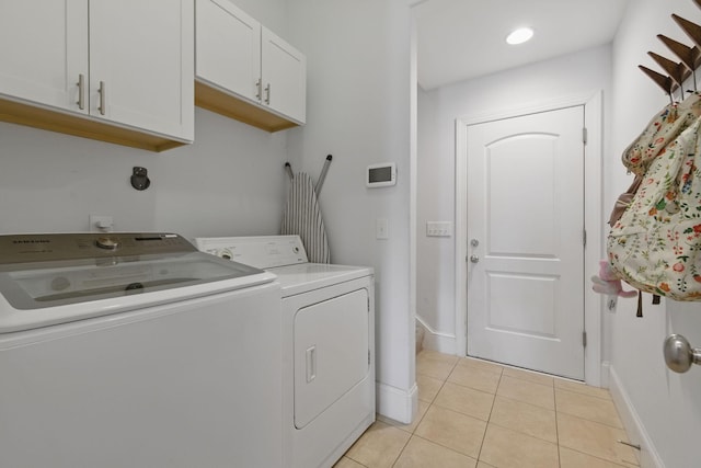 laundry room with cabinet space, light tile patterned floors, separate washer and dryer, and baseboards