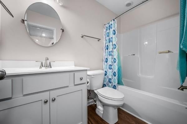 full bath featuring shower / bath combination with curtain, toilet, vanity, and wood finished floors