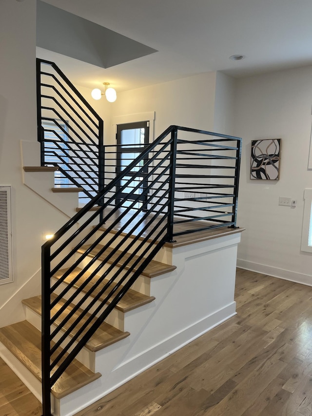 stairs featuring wood finished floors and baseboards